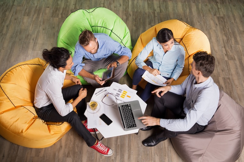 Menschen von oben an einem Tisch mit Laptops
